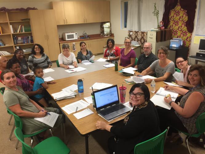 Several parents sit around a table at a Guild meeting.